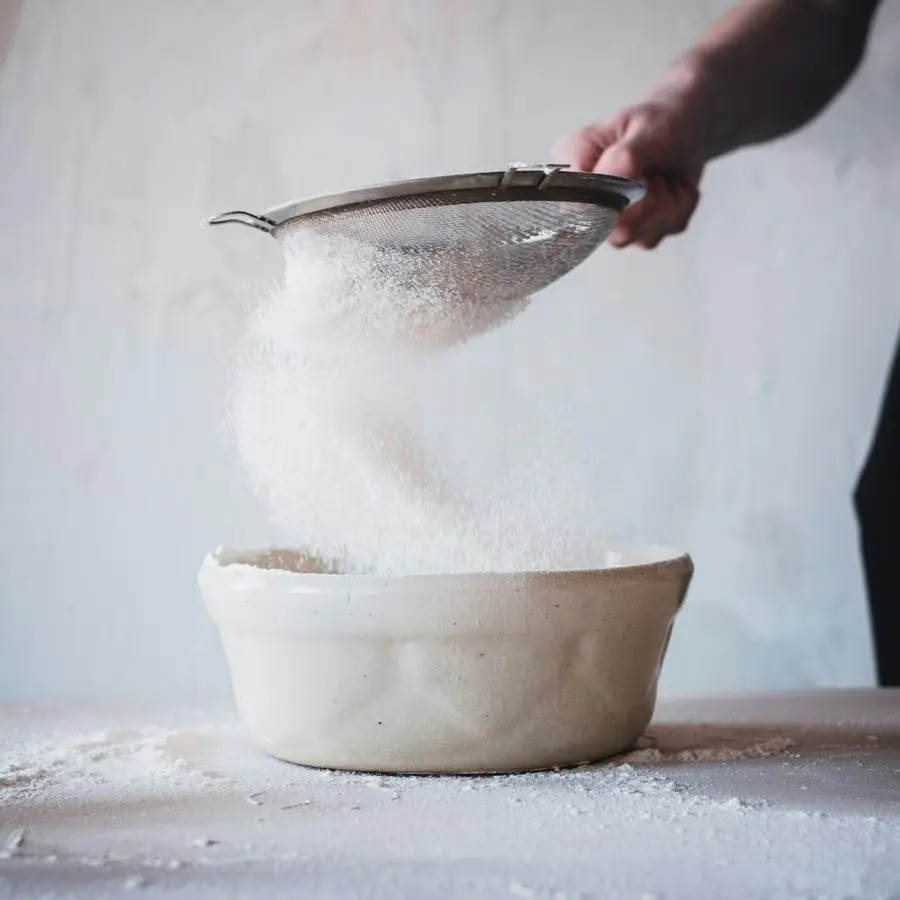 Flour being sifted into a bowl